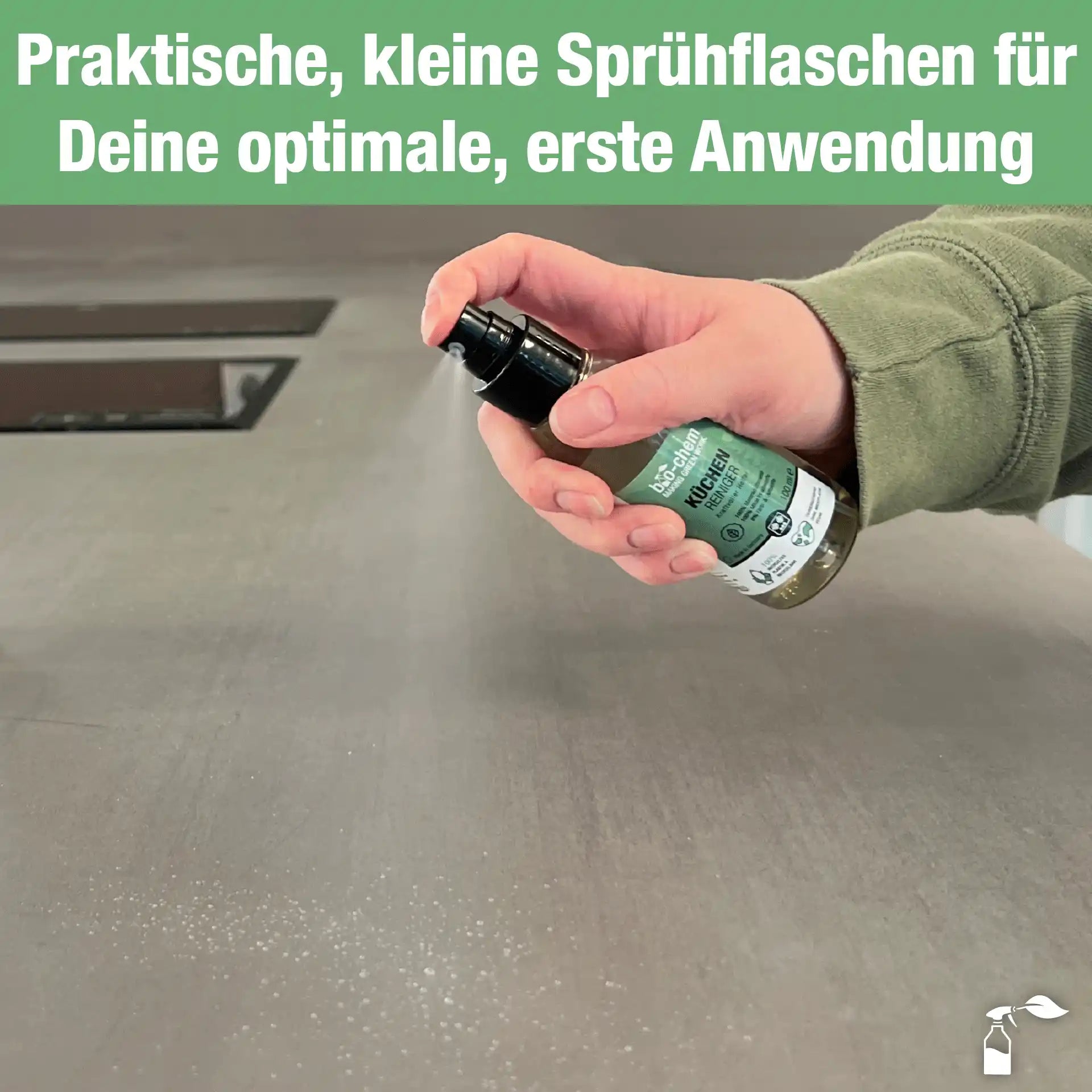 Hand sprüht Küchenreiniger auf Arbeitsfläche, feiner Sprühnebel sichtbar, für gezielte Anwendung
